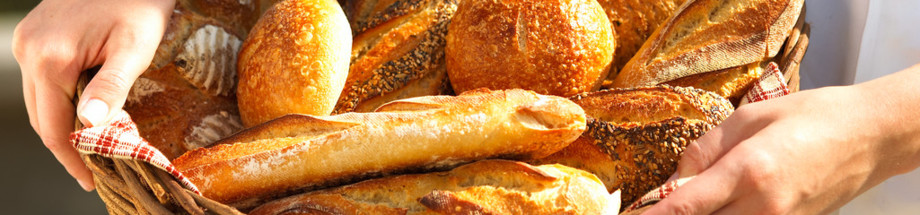 breadmaker with basket of fresh baguettes --- Image by © Jupiterimages/Brand X/Corbis